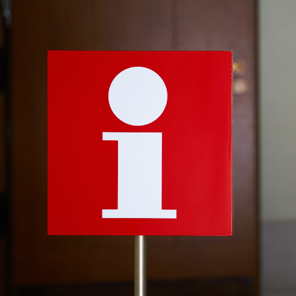 Znak na którym jest symbol informacji na czerwonym tle.